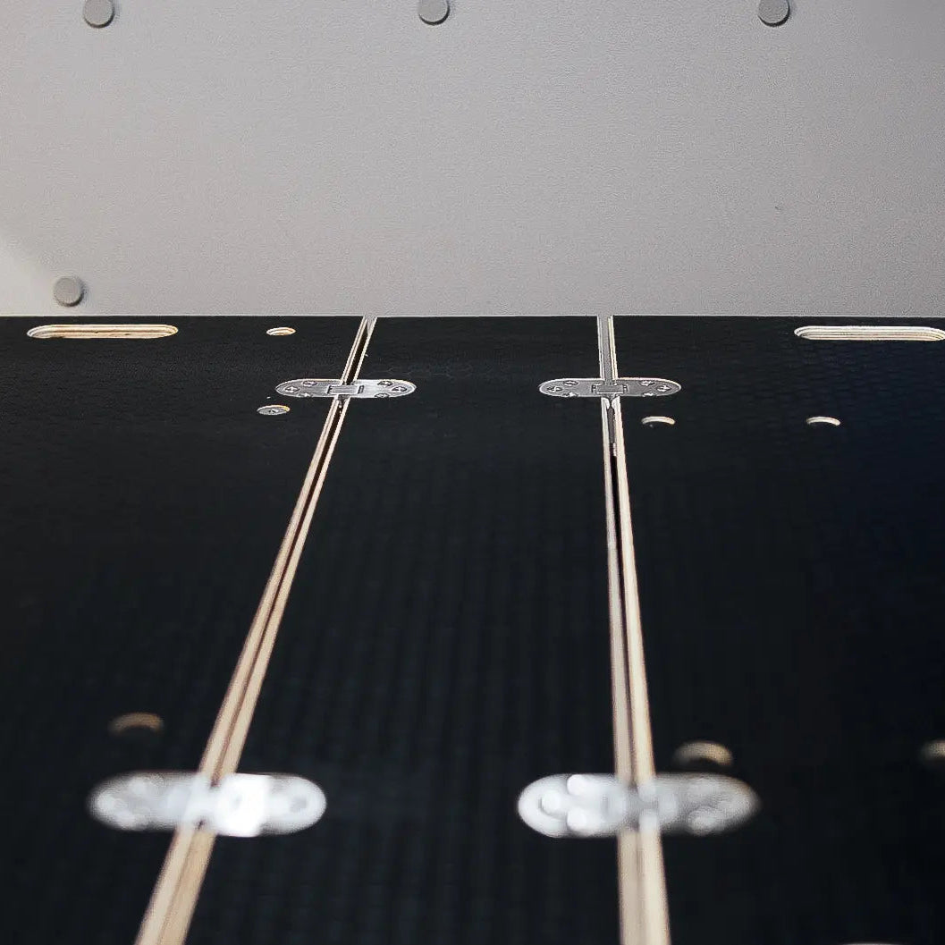 Close-up of top of Ovano dualdeck. Black phenolic plywood with stainless hinges.