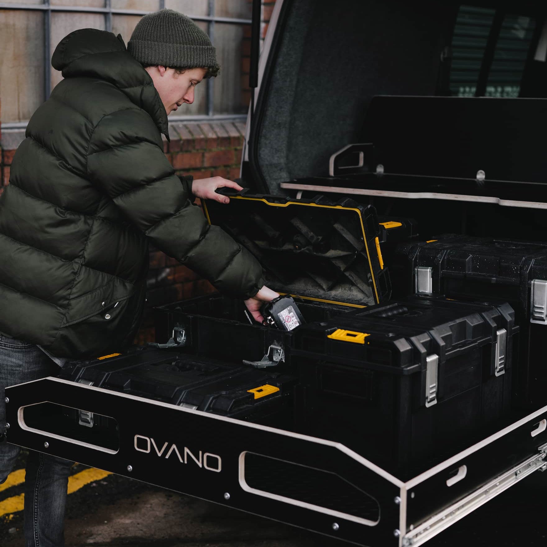 person accessing tools in dewalt tool boxes in a pull out drawer of a van