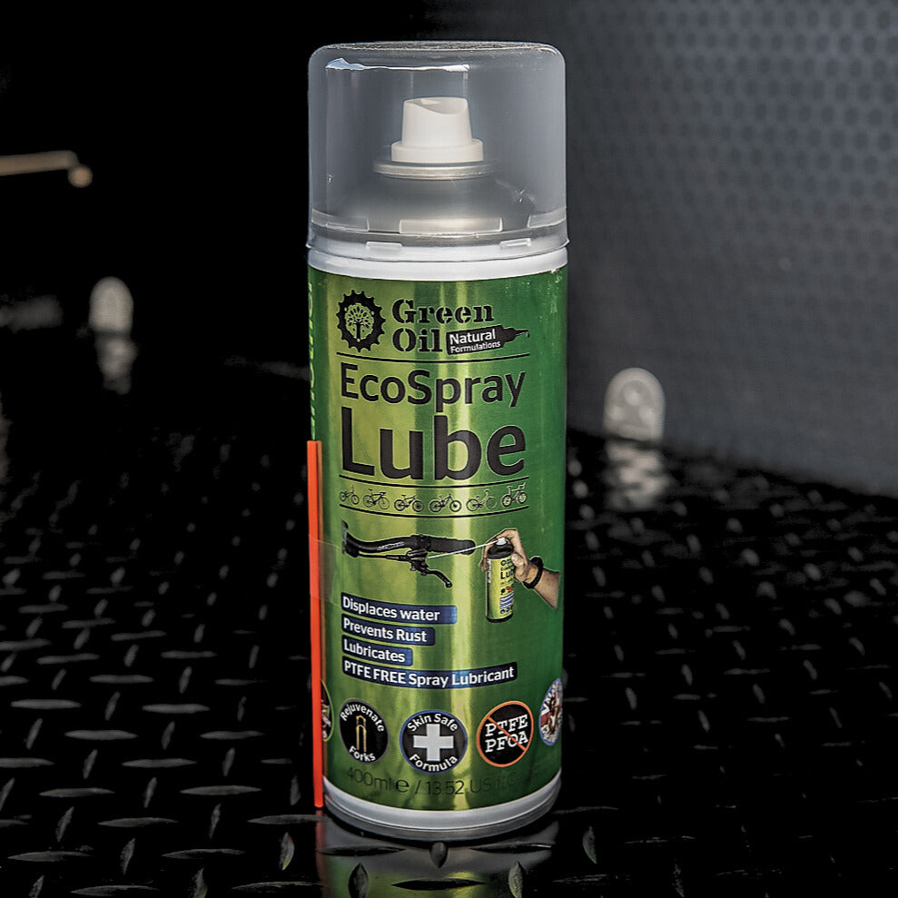 Green can of ecospray lube against a black textured background.