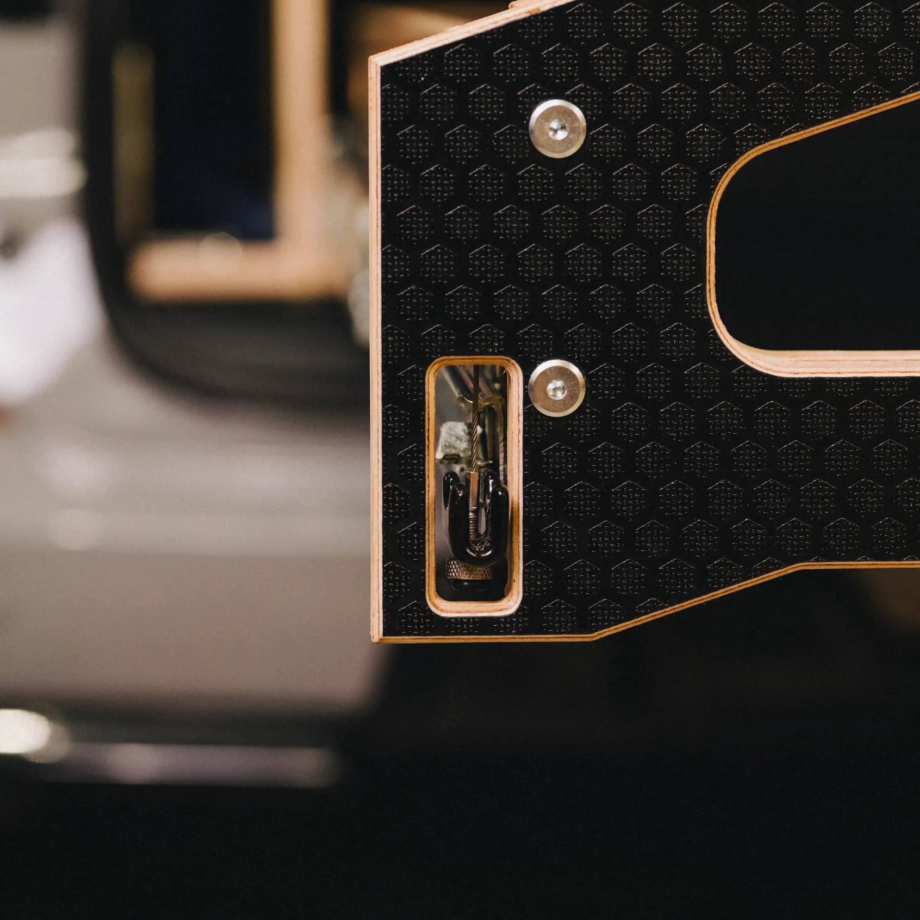 Close-up of a textured black phenolic surface with a metallic latch.