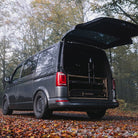 Grey van with open rear door in a forest setting. Ovano drawer and MTB fitted.