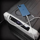 Blue smartphone charging on a portable power station with a dark background