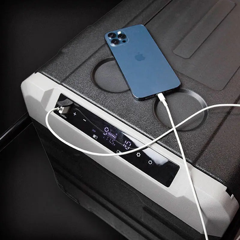 Blue smartphone charging on a portable power station with a dark background