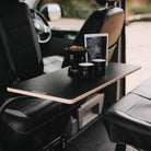 Table with coffee making kit on, inside a VW van at the beach