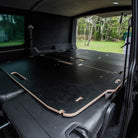 Ovano bed laid out over rear kombi seats POV from side door.