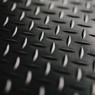 Close-up of a black diamond plate pattern rubber mat