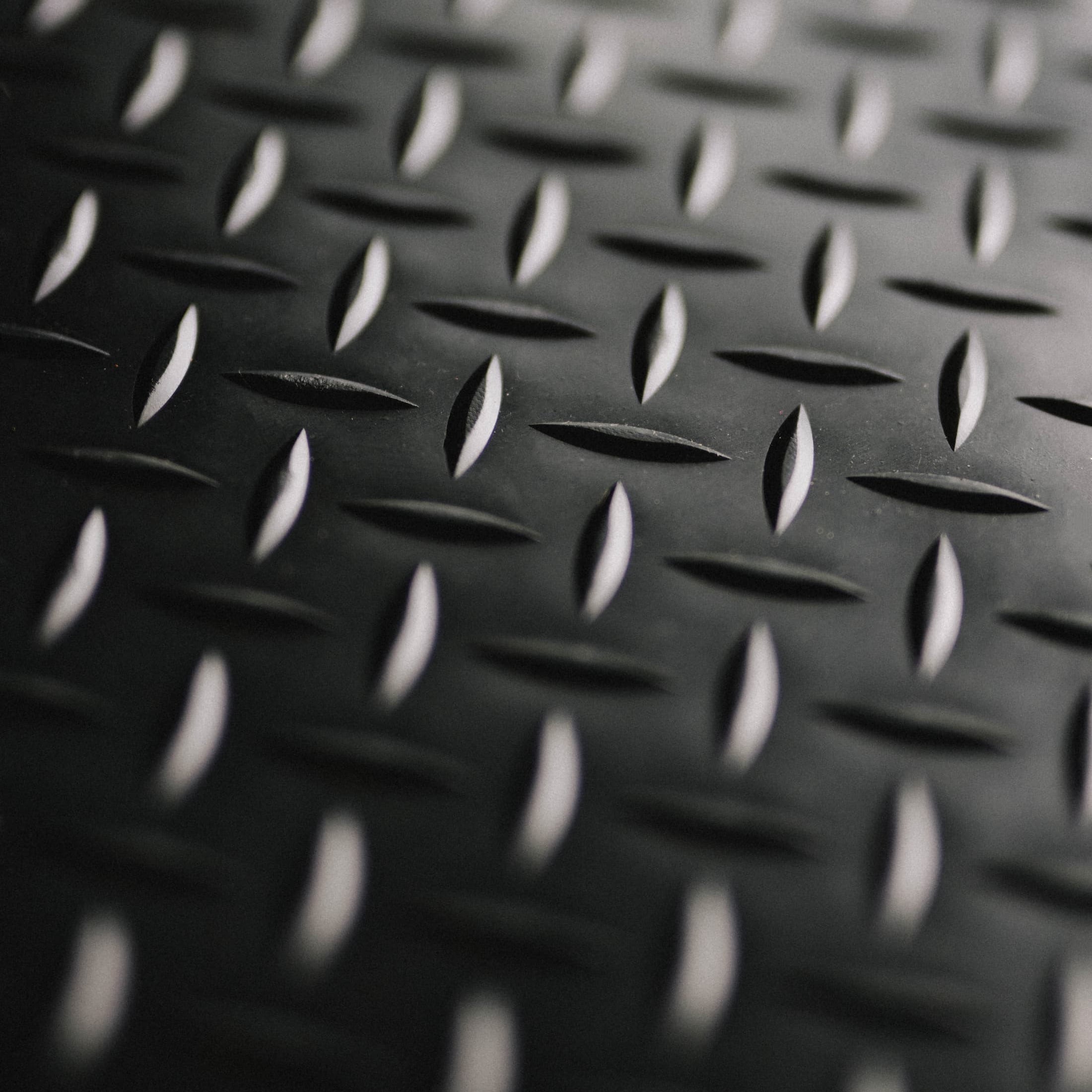 Close-up of a black diamond plate pattern rubber mat