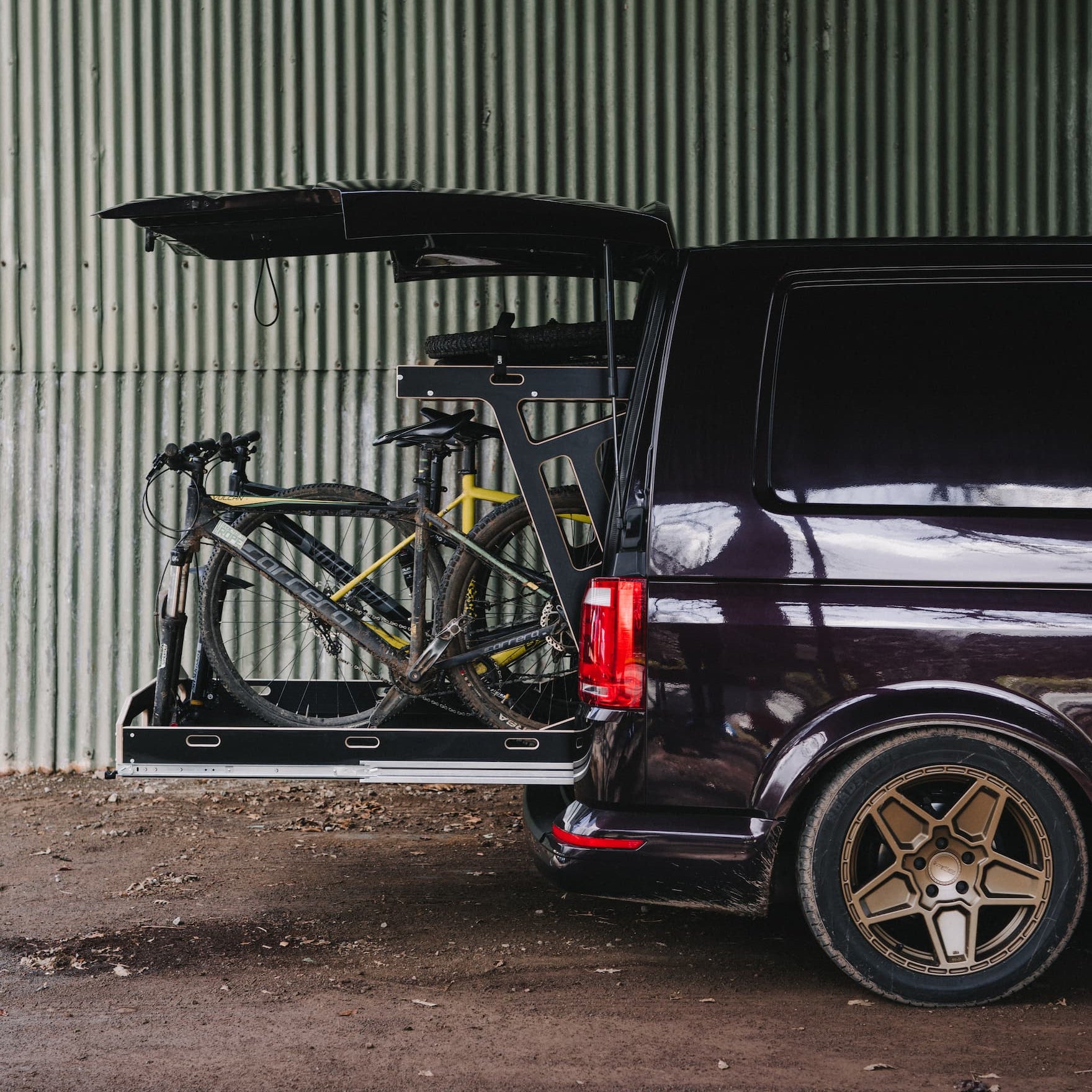 Transporter side view with pullout bike tray loaded with 3 mountain bikes